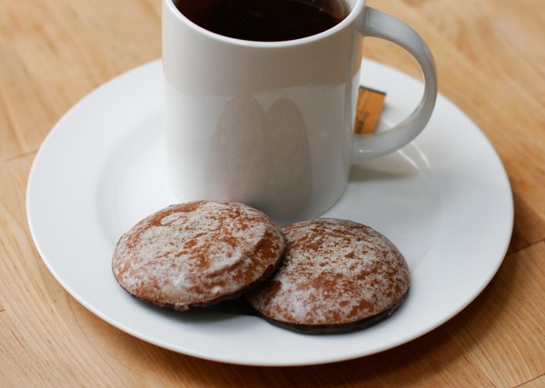 A cup of tea with two holiday spice cookies