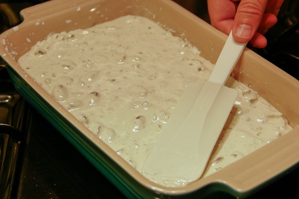 Spreading the nougat A human hand using a spatula to spread nougat in a rectangular baking dish